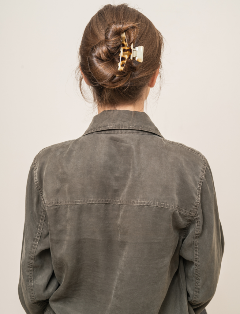Back view of woman with twisted bun hairstyle secured with claw clip
