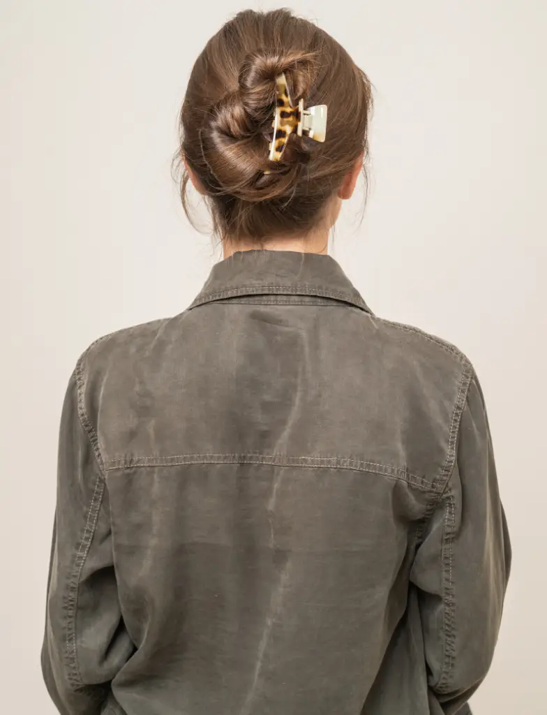 Back view of woman with twisted bun hairstyle secured with claw clip